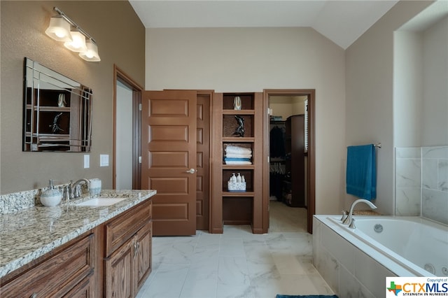 bathroom with vanity, lofted ceiling, and a bathing tub