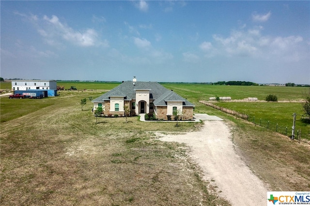 view of front of property with a rural view and a front lawn