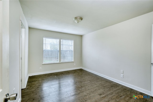 empty room with dark hardwood / wood-style flooring