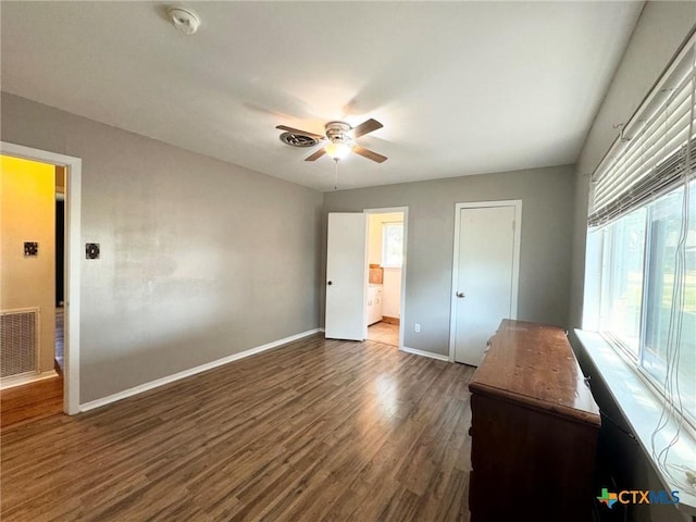 unfurnished bedroom with dark wood-type flooring, connected bathroom, and ceiling fan