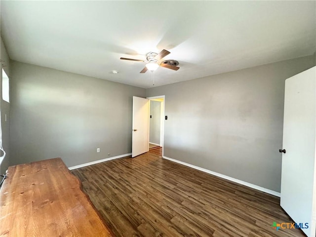 unfurnished bedroom featuring ceiling fan and dark wood-type flooring