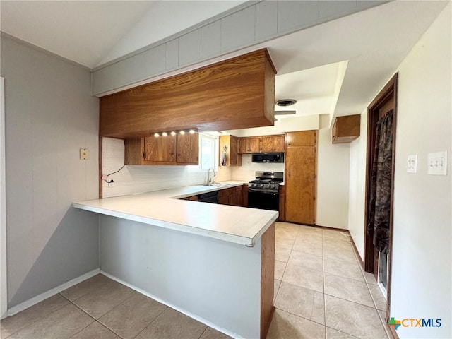 kitchen featuring light tile patterned floors, sink, vaulted ceiling, black appliances, and kitchen peninsula