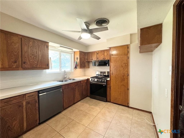 kitchen with light tile patterned floors, sink, black dishwasher, ceiling fan, and stainless steel gas range