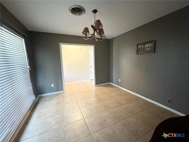 unfurnished room featuring an inviting chandelier and light tile patterned floors