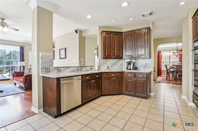 kitchen with sink, light tile patterned floors, appliances with stainless steel finishes, light stone countertops, and backsplash