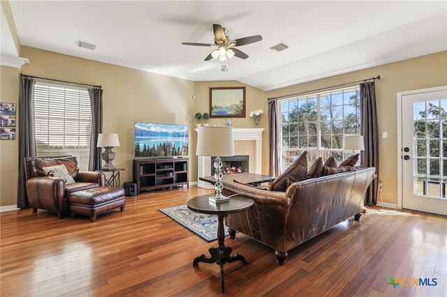 living room featuring hardwood / wood-style flooring, ceiling fan, and vaulted ceiling