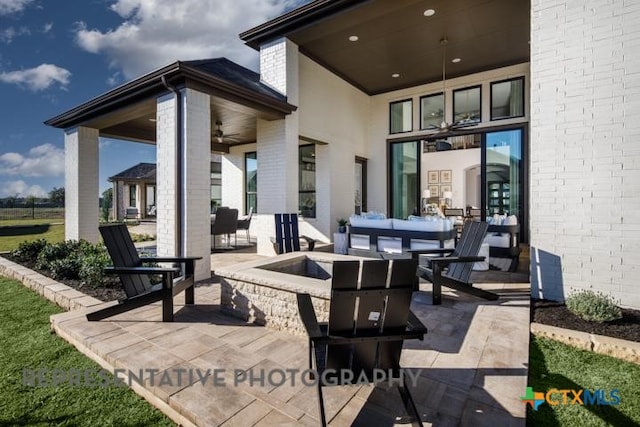 view of patio / terrace featuring an outdoor living space with a fire pit and ceiling fan