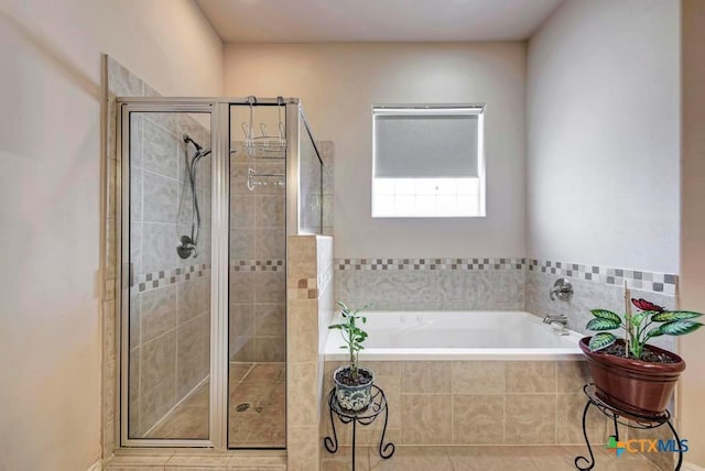 bathroom with a shower stall and a bath