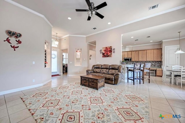 living room featuring light tile patterned floors, ceiling fan, visible vents, baseboards, and ornamental molding