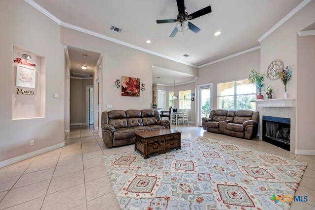 living area featuring light tile patterned flooring, visible vents, and crown molding
