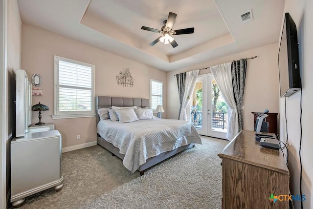 carpeted bedroom featuring baseboards, ceiling fan, access to outside, a tray ceiling, and french doors