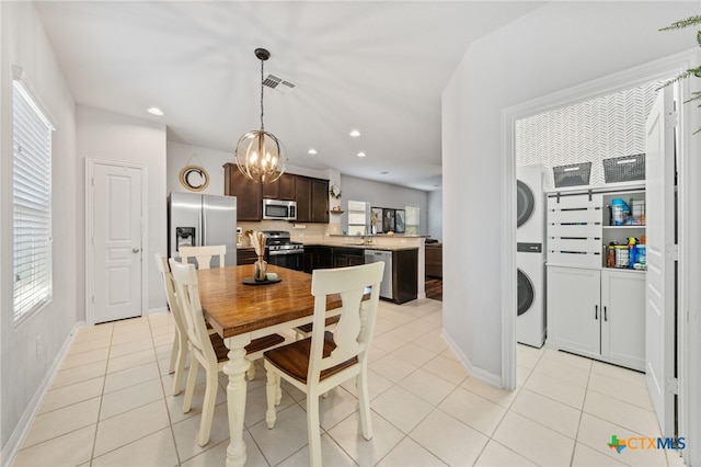 dining space featuring visible vents, baseboards, light tile patterned floors, recessed lighting, and stacked washer / drying machine