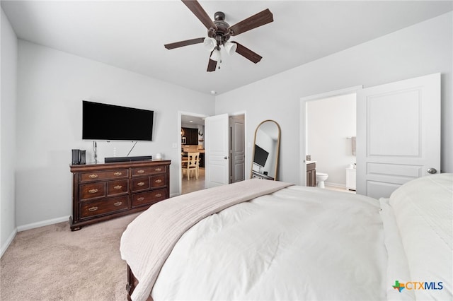 bedroom with light carpet, ceiling fan, ensuite bathroom, and baseboards