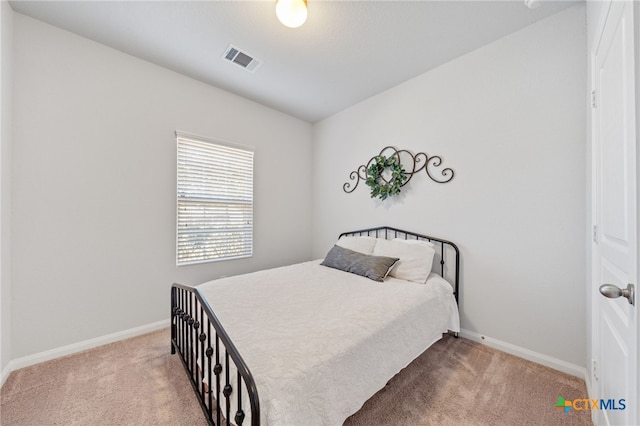 carpeted bedroom with visible vents and baseboards