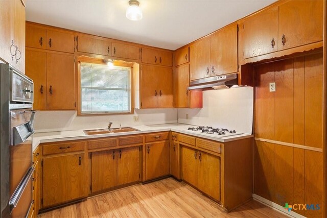 302 W Upshaw Ave, Temple, TX 76501 - kitchen featuring under cabinet range hood, white gas stovetop, a sink, light wood finished floors, and light countertops
