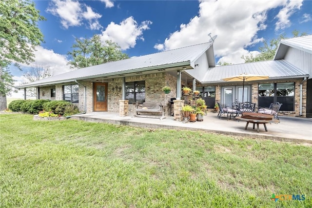 6589 State Highway 304, Harwood, TX 78632 - rear view of house featuring brick siding, a yard, metal roof, and a patio