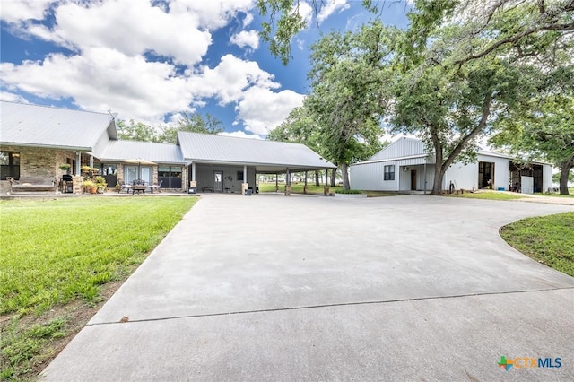 6589 State Highway 304, Harwood, TX 78632 - view of front of property featuring concrete driveway, a front yard, a carport, and metal roof