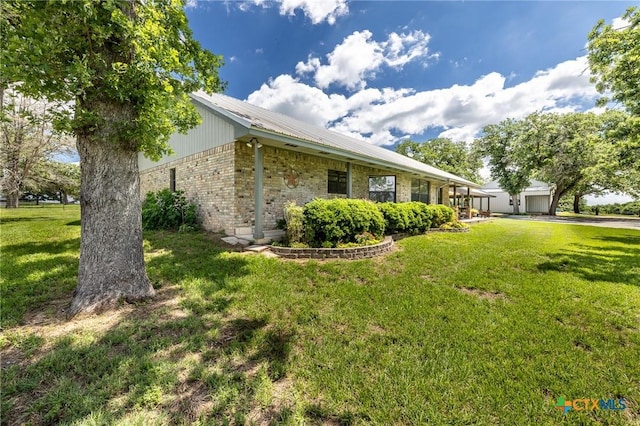 6589 State Highway 304, Harwood, TX 78632 - view of property exterior with brick siding, a lawn, metal roof, and a garage
