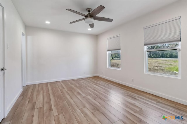 empty room with ceiling fan and light hardwood / wood-style floors