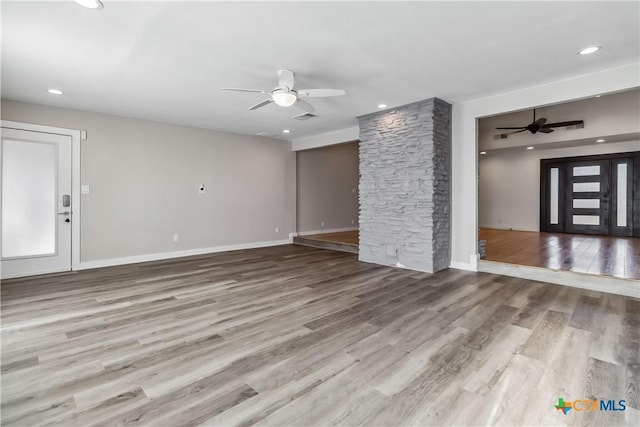 unfurnished living room featuring ceiling fan and light wood-type flooring