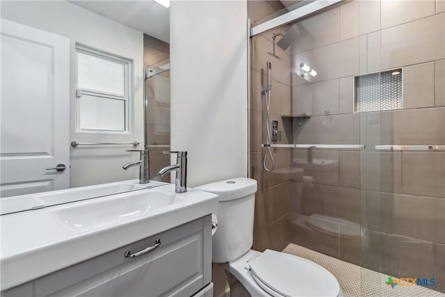 bathroom with walk in shower, vanity, and toilet