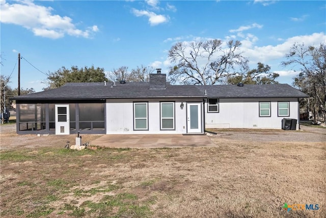 back of house with a patio area, a sunroom, and a lawn