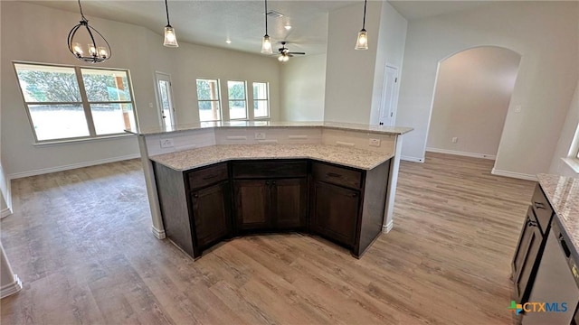 kitchen with light wood finished floors, ceiling fan with notable chandelier, arched walkways, and a healthy amount of sunlight