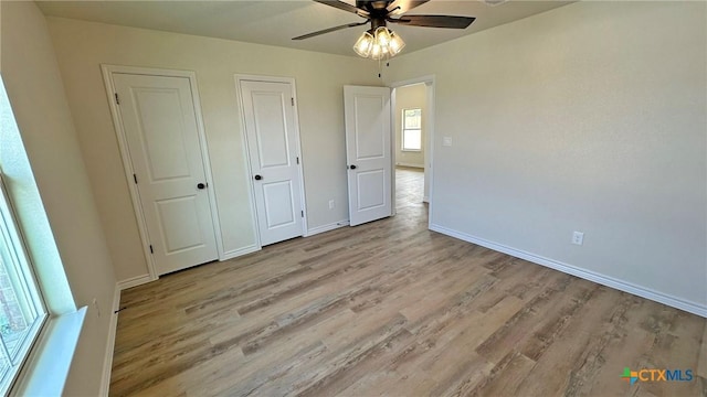 unfurnished bedroom featuring baseboards, ceiling fan, and wood finished floors