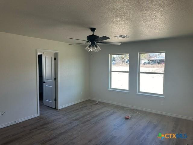 spare room featuring ceiling fan, dark hardwood / wood-style floors, and a textured ceiling