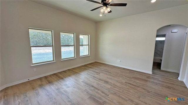 spare room featuring recessed lighting, baseboards, arched walkways, a ceiling fan, and wood finished floors