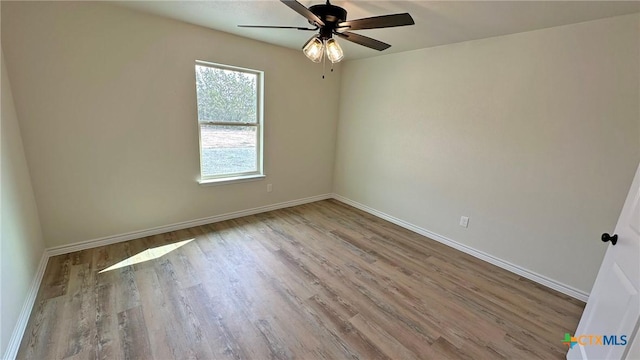 unfurnished room with wood finished floors, baseboards, and ceiling fan