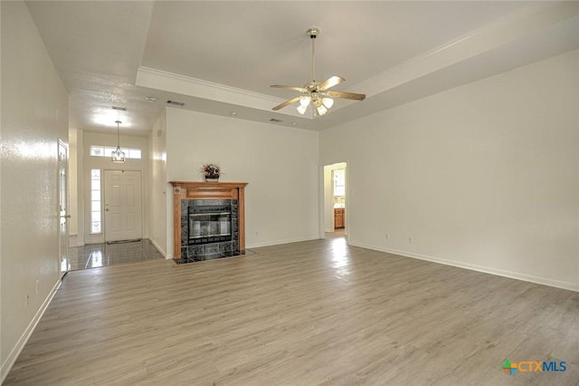 2109 Southport Dr, Killeen, TX 76542 - unfurnished living room featuring wood finished floors, a ceiling fan, a raised ceiling, a high end fireplace, and ornamental molding