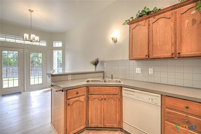 2109 Southport Dr, Killeen, TX 76542 - kitchen featuring dishwasher, a peninsula, tasteful backsplash, brown cabinetry, and light wood-style floors