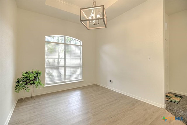 2109 Southport Dr, Killeen, TX 76542 - empty room with a chandelier, light wood-style floors, and a tray ceiling