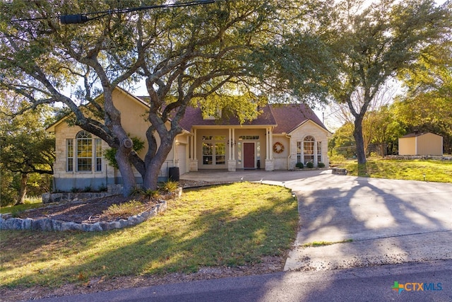 mediterranean / spanish home featuring a front yard and a storage unit