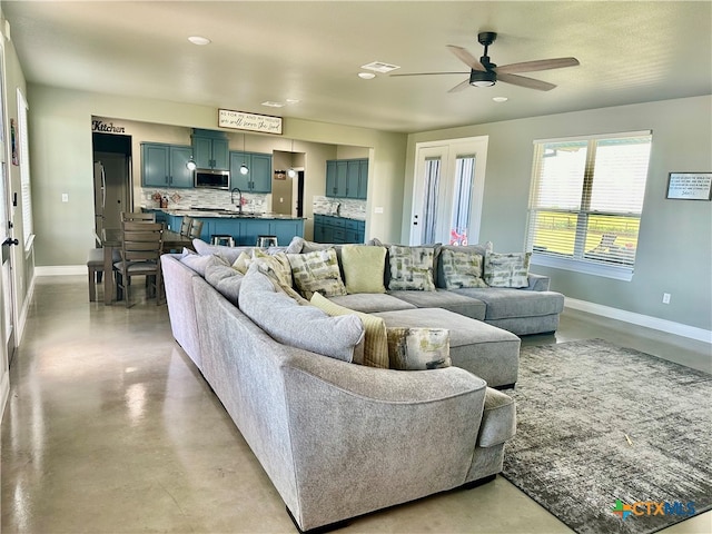 living room with ceiling fan and sink