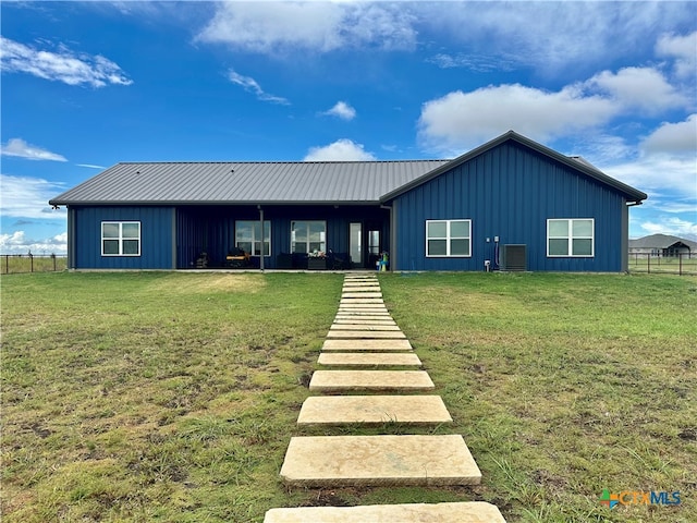 rear view of property featuring a lawn