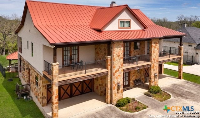 back of property featuring a garage and a balcony