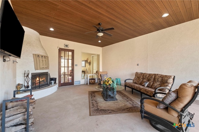 living room featuring ceiling fan and wood ceiling