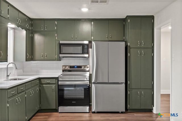3126 Glenwood Dr, Temple, TX 76502 - kitchen featuring tasteful backsplash, a sink, appliances with stainless steel finishes, dark wood finished floors, and green cabinets