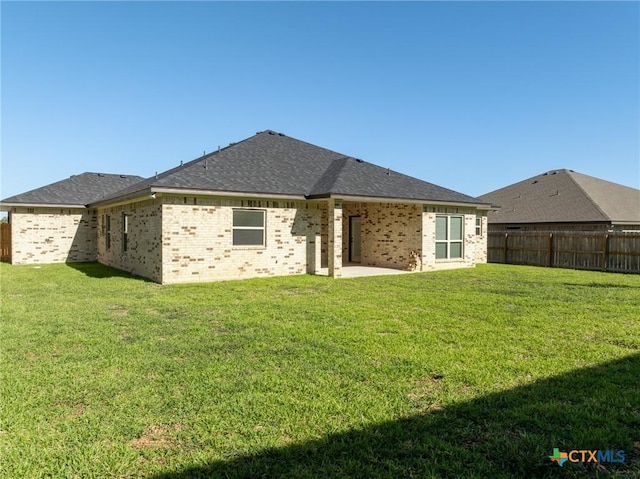 rear view of house featuring a patio area and a yard