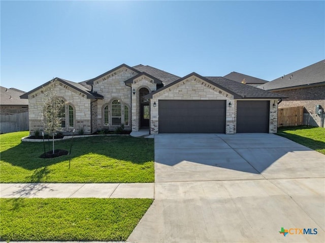 french country inspired facade featuring a front yard and a garage