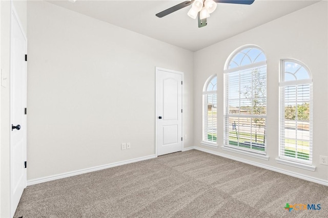 carpeted spare room with ceiling fan