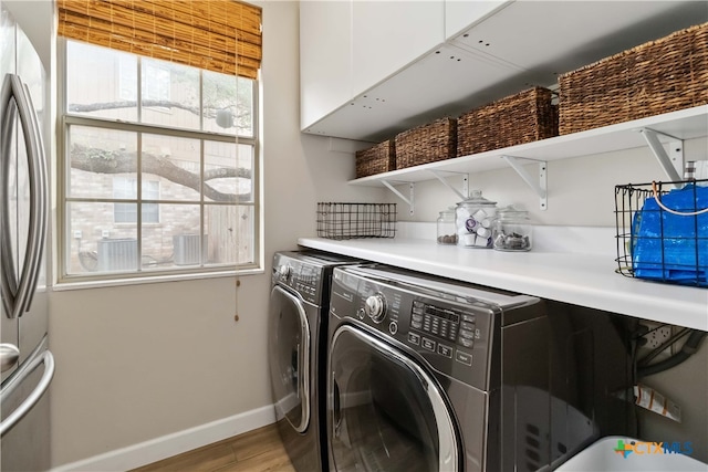 3836 Newland Ct, Round Rock, TX 78681 - clothes washing area featuring light wood finished floors, baseboards, and washing machine and dryer