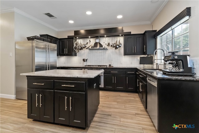 3836 Newland Ct, Round Rock, TX 78681 - kitchen featuring dark cabinets, stainless steel appliances, a kitchen island, a sink, and ornamental molding