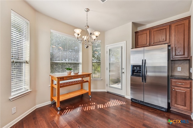 kitchen with dark hardwood / wood-style flooring, plenty of natural light, stainless steel refrigerator with ice dispenser, and an inviting chandelier