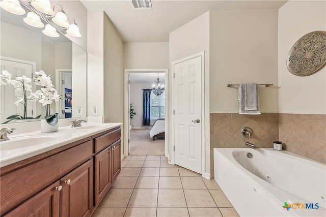 bathroom with tile patterned flooring, vanity, a bathtub, and a chandelier