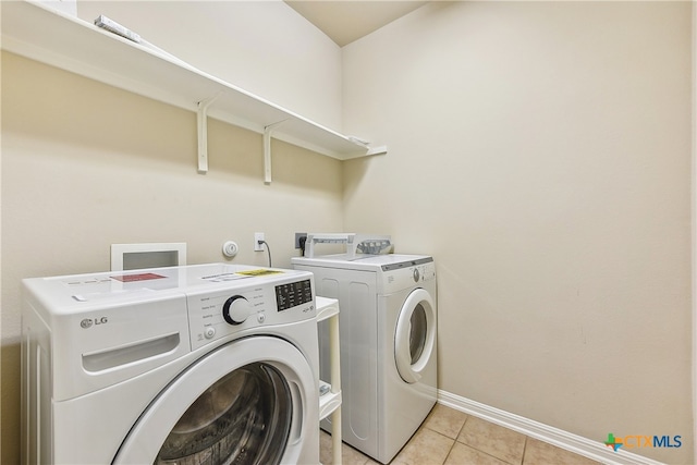 laundry area featuring separate washer and dryer and light tile patterned flooring