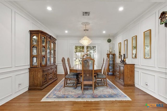2113 Highland Dr, Salado, TX 76571 - dining room with a decorative wall, a chandelier, light wood-style floors, crown molding, and recessed lighting
