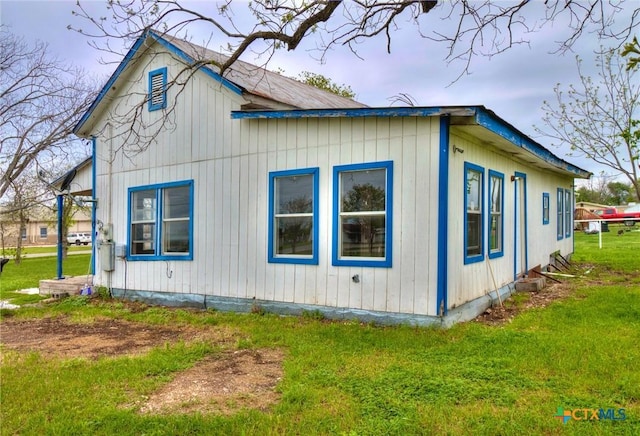 view of side of home with a yard